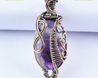 May include: An oval-shaped purple amethyst gemstone pendant encased in intricate copper wire wrapping. The metalwork features swirling loops and a dense coil pattern surrounding the stone, with a decorative wire bail at the top for hanging.