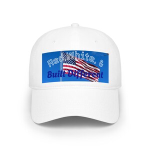 May include: White baseball cap with a blue rectangle featuring an American flag and the text "Red, White, & Built Different". The cap has a curved peak and a button on top.