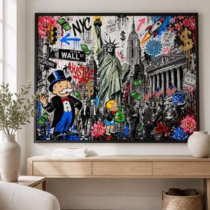 Peut inclure: Une impression d'art murale encadrée présentant un collage d'icônes de New York, notamment la Statue de la Liberté, l'Empire State Building, des panneaux Wall Street, le personnage Monopoly, Richie Rich, un taureau, des fusées et des billets.