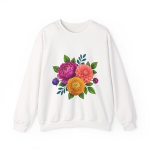 Op de afbeelding: Een wit sweatshirt met lange mouwen en een centrale grafische print van een kleurrijk boeket bloemen. Het boeket bestaat uit een grote magenta pioenroos, een koraalkleurige dahlia, een gele ranonkel en kleine paarse knoppen.