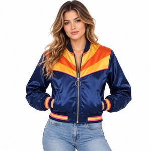 Könnte beinhalten: Eine marineblaue Satin-Bomberjacke mit einem Chevron-Muster in Gelb und Orange auf der Brust. Die Jacke hat einen goldfarbenen runden Reißverschlussanhänger, lange Ärmel mit gestreiften Rippbündchen und einen passenden gestreiften Rippsaum.