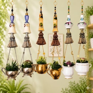 May include: A collection of hanging planters, each featuring a unique design. The planters are suspended by chains and adorned with decorative elements like tassels, beads, and ceramic toppers. The pots are in the shape of teacups and teapots, holding small plants.