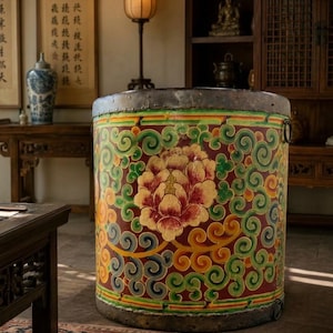 May include: A large cylindrical storage vessel featuring a deep red base color adorned with a prominent central peony flower motif in shades of pink and yellow, surrounded by intricate green and yellow swirling patterns and metal rims.