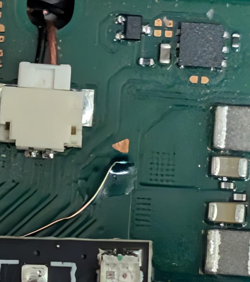 K&ouml;nnte beinhalten: Nahaufnahme einer gr&uuml;nen Leiterplatte mit verschiedenen elektronischen Bauteilen. Ein wei&szlig;er Stecker, Kupferdraht und mehrere kleine, rechteckige und quadratische Bauteile sind sichtbar. Die Platine hat Kupferspuren und L&ouml;tstellen.