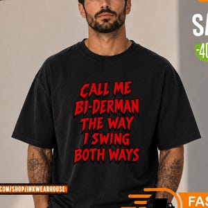 Può includere: Una t-shirt nera a maniche corte con testo rosso sul davanti che recita: CALL ME BI-DERMAN THE WAY I SWING BOTH WAYS. La maglia presenta un girocollo e una vestibilità rilassata, con la grafica stampata in un carattere audace e stilizzato.