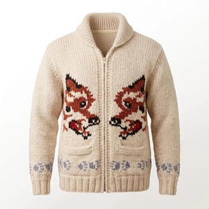 May include: Cream-coloured, zip-up cardigan sweater with a shawl collar. The sweater features two fox-like designs in brown, black, and red on the front. The bottom hem has a repeating floral pattern in blue and grey. Two pockets are visible.