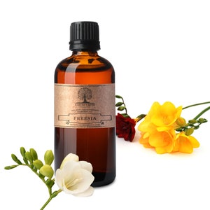 May include: A brown glass bottle with a black cap, labeled "Nature's Note" Freesia 100% Pure Aromatherapy Essential Oil. The bottle is sitting on a white surface with yellow and red freesia flowers.