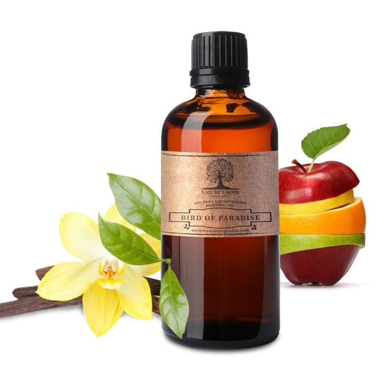 Puede incluir: Una botella de vidrio marr&oacute;n de aceite esencial "Bird of Paradise" con tapa negra y etiqueta beige. La imagen incluye una manzana, naranja y fruta verde en rodajas, junto con una flor amarilla, hojas verdes y una vaina de vainilla marr&oacute;n.