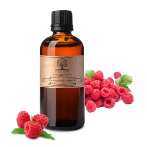 Pode incluir: Uma garrafa de vidro marrom com uma tampa preta cheia de líquido âmbar. A garrafa tem um rótulo que diz "Nature's Note Organics 100% Pure Aromatherapy Essential Oil Raspberry Spice naturesnoteorganics.com". A garrafa está sobre uma superfície branca ao lado de um monte de framboesas vermelhas.