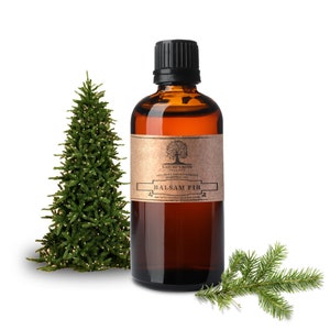 Può includere: Una bottiglia di vetro marrone con un tappo nero riempita di olio essenziale di abete balsamico. La bottiglia ha un'etichetta di carta marrone con il testo "Nature's Note 100% Pure & Aromatherapy Essential Oil Balsam Fir naturesnoteorganics.com". La bottiglia è appoggiata su una superficie bianca con un piccolo albero di Natale artificiale e un rametto di abete.