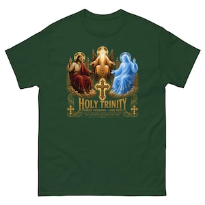 Puede incluir: Una camiseta verde oscuro con un gráfico de la Santísima Trinidad. El diseño muestra tres figuras sentadas en tronos con halos, una cruz central y el texto "HOLY TRINITY THREE PERSONS ONE GOD" junto con un texto religioso más pequeño.