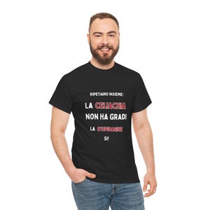 Può includere: T-shirt nero con la scritta "RIPETIAMO INSIEME: LA CELIACHIA NON HA GRADI LA STUPIDAGINE SI!" in bianco e rosso. La maglietta è indossata da una persona con jeans blu.