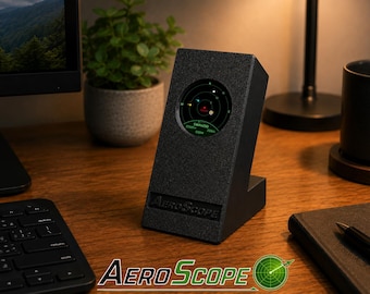 May include: A black, angled desktop device labeled AeroScope with a circular digital display showing a radar interface. The screen features a green circular grid with various data points, including the text SWA4250 and 70km, set in a dark housing.