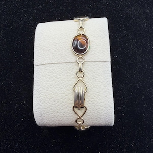Pulsera Ninfa de Madera de Sarah Coventry: Joyería llamativa de los años 70 con cabujón marrón en tono dorado.