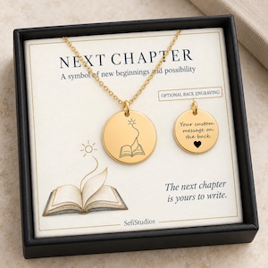 May include: A gold-toned circular pendant necklace featuring an engraved open book with a rising sun. The display card reads NEXT CHAPTER, A symbol of new beginnings and possibility, and The next chapter is yours to write, with a second disc showing Your custom message on the back.