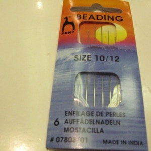 May include: A pack of 6 Pony beading needles, size 10/12, in a blue and orange packet with the text "BEADING" and "SIZE 10/12". The packet also includes the text "ENFILAGE DE PERLES", "AUFFADELNADELN", "MOSTACILLA", "#07803/01", and "MADE IN INDIA".