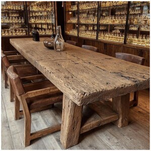 Peut inclure: Une table &agrave; manger rectangulaire en bois rustique avec une finition vieillie, soutenue par des pieds &eacute;pais et robustes. La table est entour&eacute;e de chaises en bois avec des assises en cuir. Des bouteilles en verre d&eacute;coratives sont pos&eacute;es sur la table.