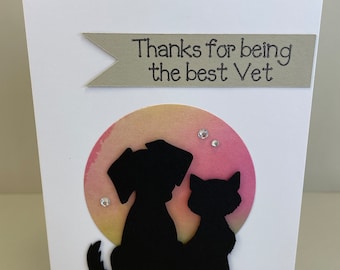 May include: A white card with a green banner that says "Thanks for being the best Vet". The card has a watercolor-style background with a silhouette of a dog and cat.