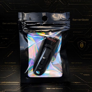 Può includere: Una chiavetta USB nera con il marchio "Sandisk" in lettere rosse, confezionata in una busta trasparente e iridescente. La busta è sigillata in un sacchetto di plastica nero con la scritta "ServerGodz".