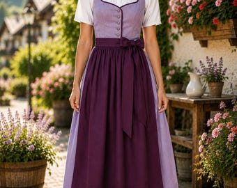 May include: A dirndl dress featuring a light purple bodice with a row of small silver buttons, a white short-sleeved blouse underneath, and a dark purple apron tied at the waist with a bow. The skirt is light purple and reaches below the knees.
