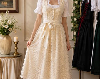 May include: A cream-colored lace dirndl dress featuring a square neckline, a fitted bodice with a front button closure, and a matching satin ribbon tie at the waist. The dress is layered over a white blouse with short, puffed sleeves and a ruffled trim.