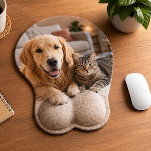 Könnte beinhalten: Benutzerdefiniertes Mauspad mit einem Golden Retriever und einer getigerten Katze. Das Mauspad hat eine Handgelenkauflage und ist mit einem Foto der beiden Haustiere gestaltet. Der Hintergrund zeigt ein Wohnzimmer.
