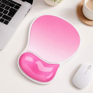 May include: A mouse pad with a white border and a pink gradient surface featuring a raised, gel-filled wrist rest in a vibrant, solid hot pink color. The ergonomic design provides a smooth area for mouse movement and support for the wrist.