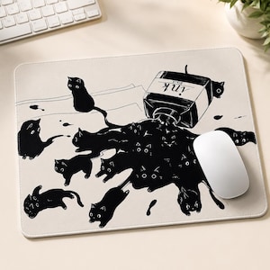 May include: A cream-coloured rectangular mouse mat with a quirky illustration. Black ink spills from a bottle labelled "Ink", forming the shape of numerous black cats. A white computer mouse rests on the mat.