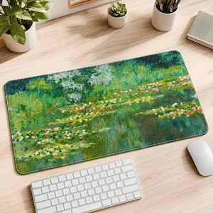 Op de afbeelding: Een rechthoekige bureaumat met een impressionistisch schilderij van een waterlelievijver. Het ontwerp toont levendige tinten groen, geel en wit, met drijvende bloemen en weelderig gebladerte dat reflecteert op het wateroppervlak met zachte streken.
