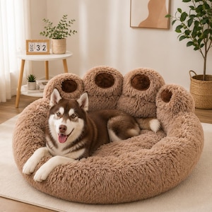 Peut inclure: Un chien brun et beige se repose dans un lit pour animaux en forme de patte. Le lit est de couleur marron clair avec des accents marron plus foncés. Le lit a une texture douce et moelleuse, et le chien semble à l'aise.