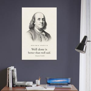 Peut inclure: Une affiche murale verticale présentant un portrait gravé en noir et blanc de Benjamin Franklin. Sous le portrait, le texte indique : BENJAMIN FRANKLIN, Well done is better than well said., Benjamin Franklin. Le fond est de couleur crème.