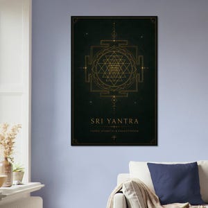 Può includere: Una stampa artistica incorniciata con un design geometrico dorato di Sri Yantra su sfondo verde scuro. Il testo "SRI YANTRA" è centrato sotto il disegno, con "COSMIC GEOMETRY & MANIFESTATION" sotto. La stampa è su un muro blu.