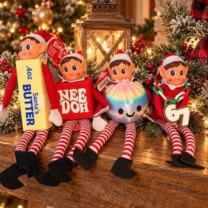 May include: Four elf dolls with red and white striped legs and black shoes. The first holds a yellow box labeled .4oz Santa's BUTTER. The second holds a red cube labeled NEE DOH. The third holds a round, iridescent, smiling ball. The fourth holds a green chain with the number 5.