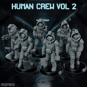 May include: A set of six grey miniature figures in detailed space suits with helmets, standing on circular black bases. The text HUMAN CREW VOL 2 is displayed at the top, and the word PRESUPPORTED is visible in the bottom left corner.