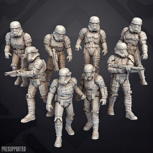 Può includere: Un set di sette miniature di soldati non dipinte, color bianco sporco, con armature tattiche e caschi, alcune delle quali impugnano fucili. Le figure presentano dettagli di piastre, cinghie ed equipaggiamento. Il testo "PRESUPPORTED" è visibile nell'angolo in basso a sinistra.