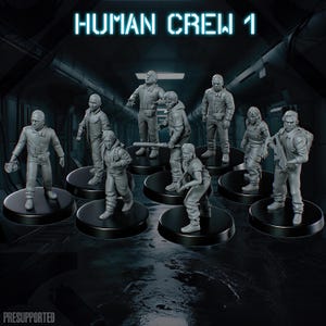 Op de afbeelding: Een set van acht grijze miniatuurfiguren met het label HUMAN CREW 1, elk op een ronde zwarte basis. De figuren staan in verschillende houdingen, dragen werkkleding en sommigen houden uitrusting of gereedschap vast in een sci-fi setting.