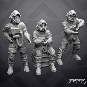 Può includere: Tre miniature in resina grigia che raffigurano piloti con equipaggiamento di volo. Uno è in piedi con la visiera abbassata, uno è seduto su una cassa e uno è in piedi con le braccia tese. Indossano tute da volo, imbracature e caschi con radio.