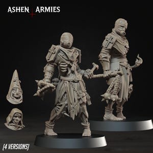 Op de afbeelding: Twee ongeverfde grijze hars miniatuurfiguren van Ashen Armies, gekleed in gescheurde bandages en harnassen met kruismotieven. Eén figuur houdt een strijdvlegel met stekels vast, de andere een knots. Twee extra verwisselbare hoofden met kap zijn inbegrepen.