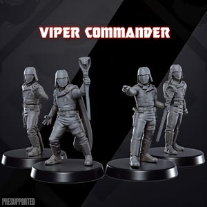 Op de afbeelding: Vier grijze Viper Commander-beeldjes op zwarte sokkels. De figuren staan in verschillende poses, sommige met wapens of een staf met een cobra-kop. De tekst "VIPER COMMANDER" staat in het rood bovenaan.