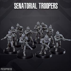 Könnte beinhalten: Ein Set aus neun grauen Miniatur-Soldatenfiguren mit der Aufschrift SENATORIAL TROOPERS, die jeweils einen Helm mit Kamm und taktische Rüstung tragen. Die Figuren stehen in verschiedenen Aktionsposen mit Gewehren auf einzelnen schwarzen Rundsockeln.