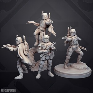 Op de afbeelding: Een set van vier ongeverfde lichtgrijze hars miniatuurfiguren van gepantserde krijgers met helmen met T-vormige vizieren, capes en jetpacks. Elk figuur houdt een blastergeweer of pistool vast, waarbij één figuur op een ronde voet staat.