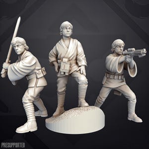 Op de afbeelding: Drie onbeschilderde, lichtgekleurde miniatuurfiguren van hars die een menselijk personage in een tuniek en gewikkelde laarzen voorstellen. Eén figuur houdt een lichtzwaard vast, één staat met een verrekijker op een voetstuk en één richt een blastergeweer.