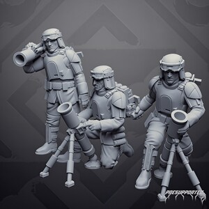May include: Three grey miniature soldier figures in tactical gear and helmets with goggles. One figure stands holding a large tube on their shoulder, while two others kneel and operate mortar-style weapons mounted on tripods. Text reads PRESUPPORTED.
