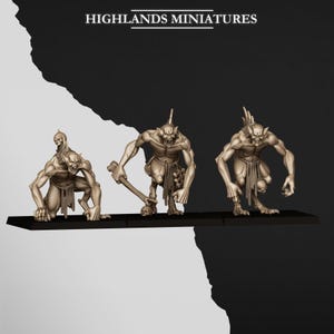 Pode incluir: Três miniaturas de criaturas fantásticas bege da Highlands Miniatures numa base retangular preta. As figuras têm orelhas pontiagudas, corpos musculados e tangas. Uma segura uma clava, enquanto outra transporta um pequeno crânio.