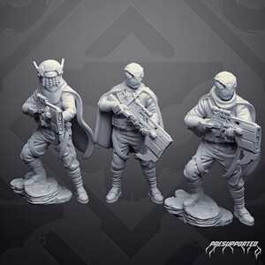 Peut inclure: Trois figurines miniatures grises debout sur des socles rocheux, portant chacune une cape et tenant un fusil futuriste. Les figurines présentent des vêtements texturés détaillés, des jambières enveloppées et des casques distincts, avec le texte PRESUPPORTED en bas.