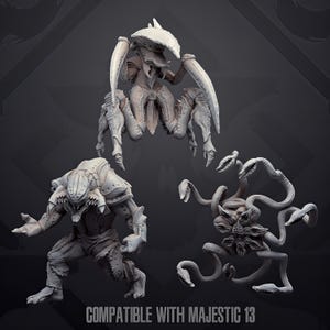 Op de afbeelding: Drie ongeverfde grijze hars miniaturen voor tabletop spellen. Eén is een krabachtig wezen met grote scharen, één is een forse humanoïde figuur met pantserplaten en één is een entiteit met vele tentakels. Onderaan staat COMPATIBLE WITH MAJESTIC 13.
