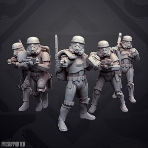 Könnte beinhalten: Ein Set aus vier unbemalten grauen Harz-Miniaturfiguren, die Soldaten in vollständiger taktischer Rüstung und Helmen darstellen. Jede Figur ist mit einem Blastergewehr und einem Rucksack ausgestattet, eine Figur zeigt nach vorne. Text PRESUPPORTED.