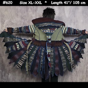 May include: A long coat featuring a patchwork design with various fabric textures and patterns in shades of olive green, dark brown, black, and blue. The garment includes a hood, long sleeves, and a flared hemline. Text reads #620, Size XL-XXL, Length 41".