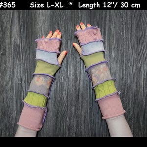 Peut inclure: Une paire de mitaines sans doigts rose, verte et violette avec un détail bouton. Les mitaines mesurent 30 cm de long et sont de taille L-XL.
