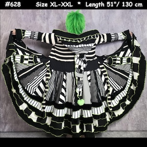May include: A long, hooded coat featuring a black and white striped pattern with various vertical and horizontal orientations. The garment includes a hood, long sleeves, and a flared hem with lime green trim and a lime green pom-pom. Text: #628 Size XL-XXL * Length 51"/ 130 cm.